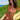 A woman with curly brown hair relaxes on a yellow lounge chair on a grassy hill overlooking the blue ocean. She is wearing a red and white gingham bikini.