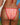 A woman shown from behind wearing a red and white gingham bikini with red trim, standing outdoors with the ocean and blue sky in the background.